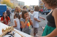 Ball State music students help children play musical instruments at last year's Muncie Arts Walk