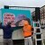 Volunteers for MuncieArts reinstalling a portrait panel in downtown Muncie.